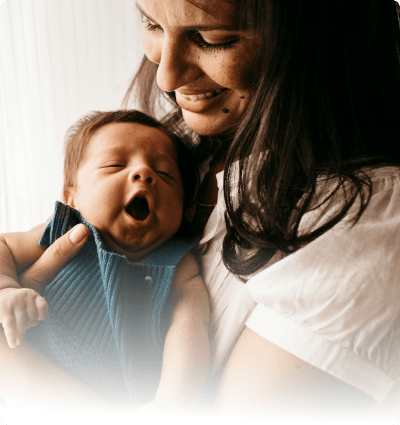 A woman holding a baby serious